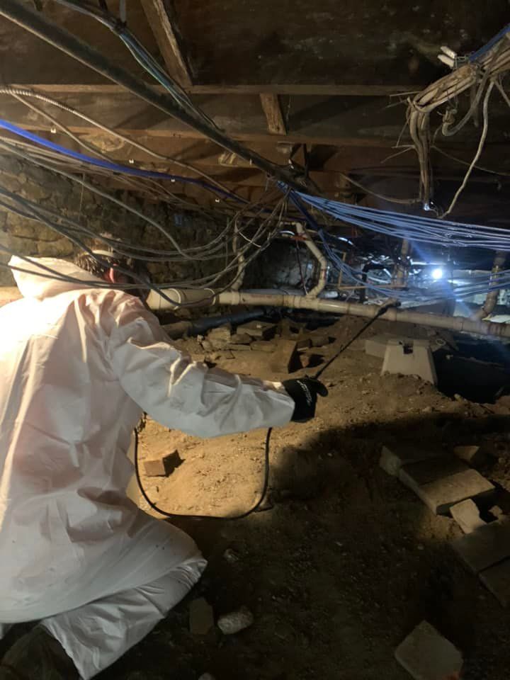 A man in a white suit is kneeling down in a basement.