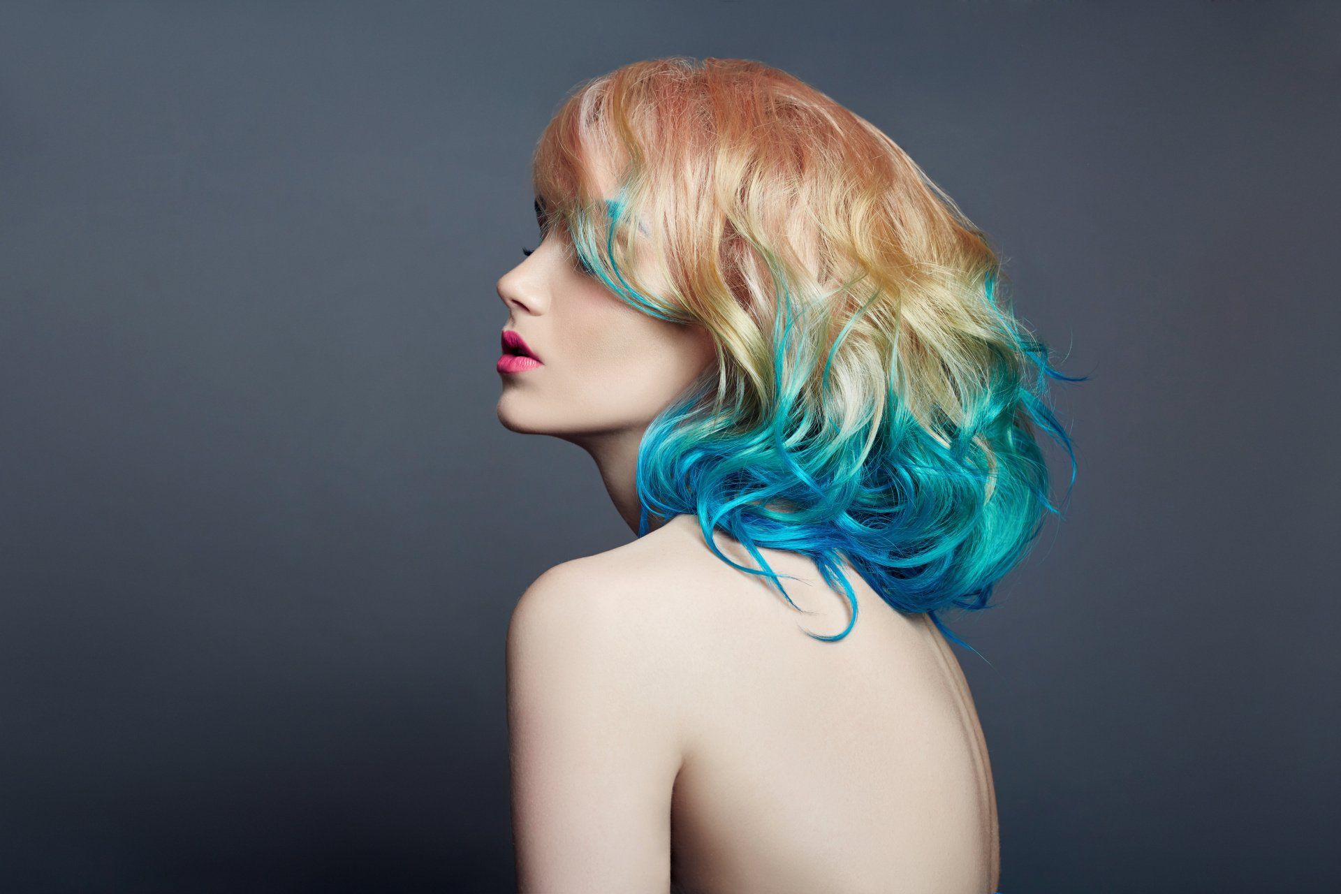 Portrait woman with bright colored flying hair, all shades of purple blue.