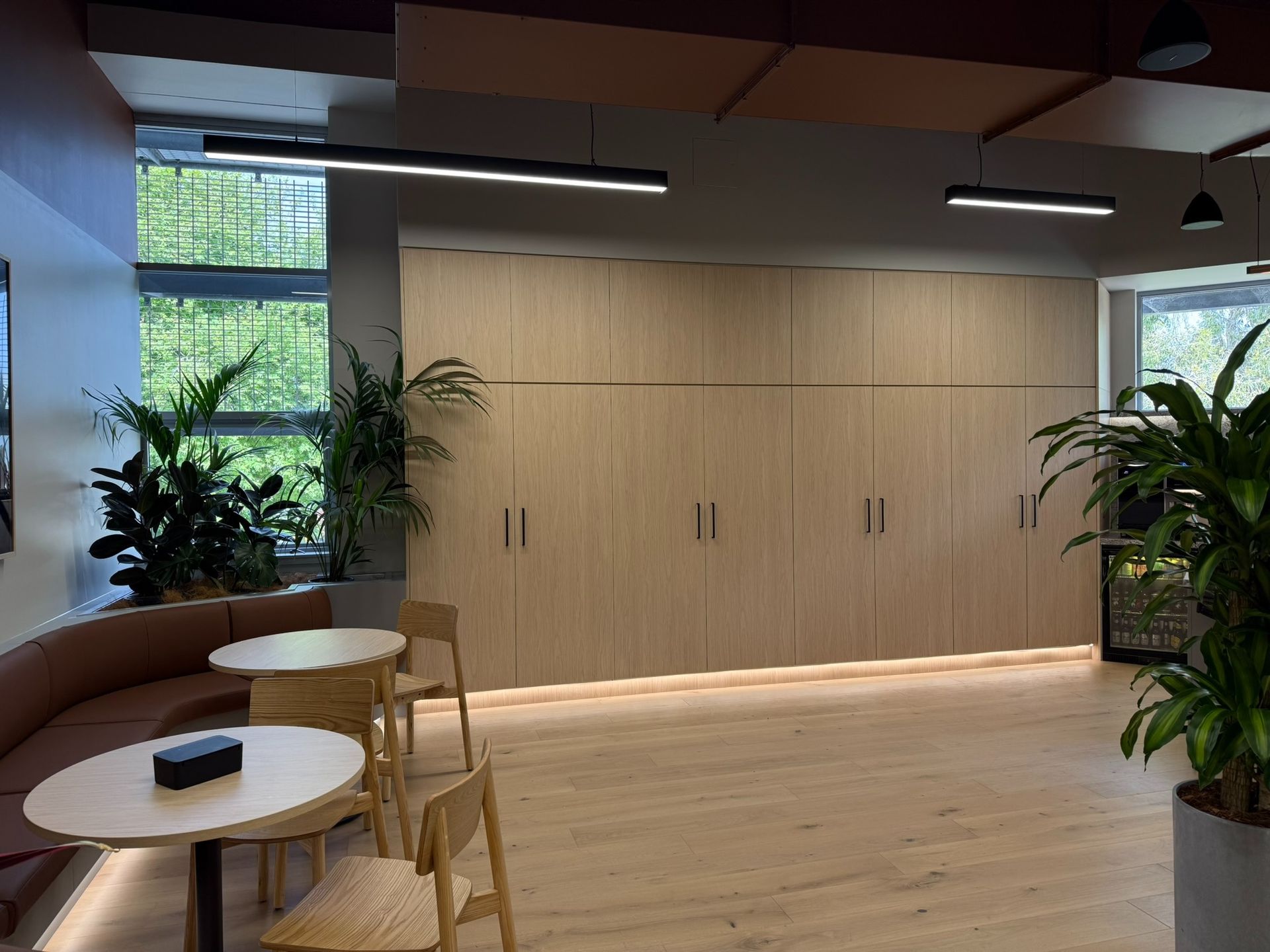 Room With Built-in Wooden Cabinets, Tables, Chairs, and Potted Plants — Zeal Interiors in Eastern Creek, NSW
