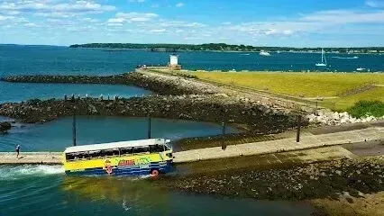 Chimney sweep portland maine -Amphibious bus entering the water with a lighthouse and sailboats in the background.