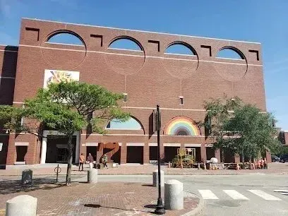 Chimney sweep portland maine-Modern brick building with arched windows and a rainbow mural on a sunny day.