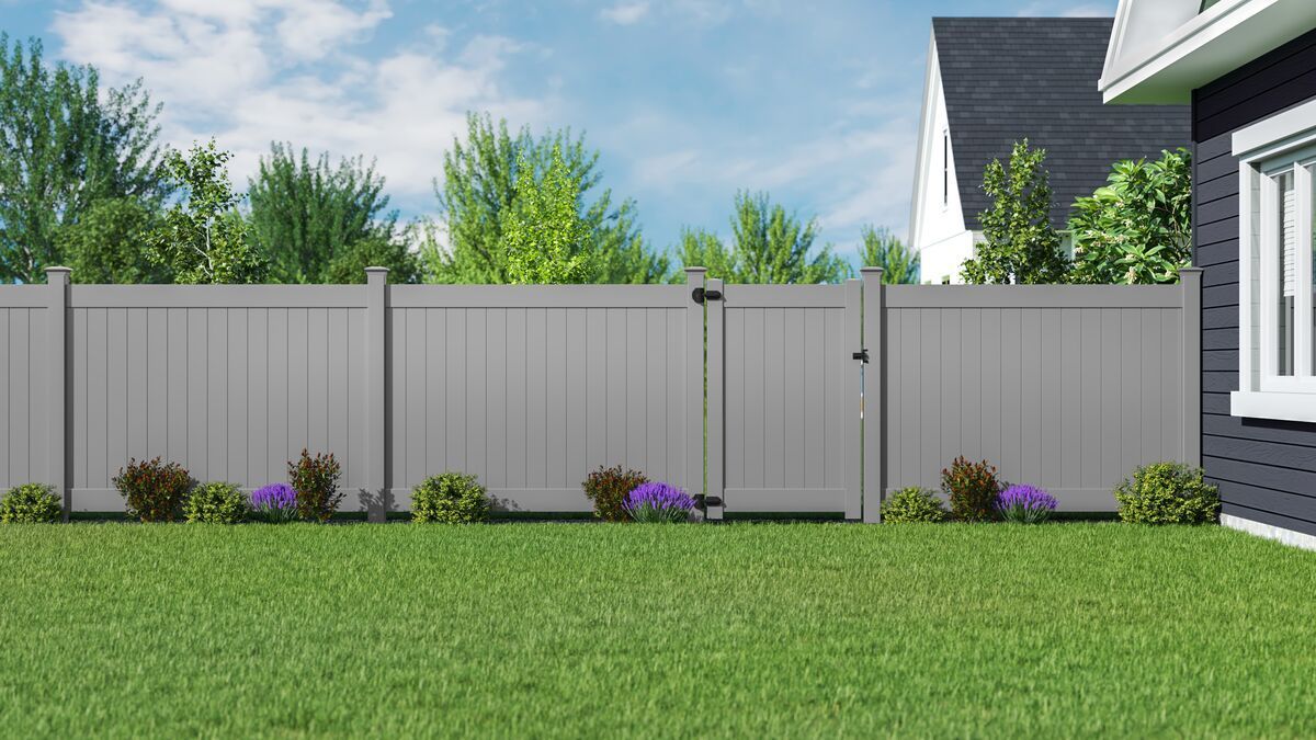 There is a fence and a gate in the backyard of a house.