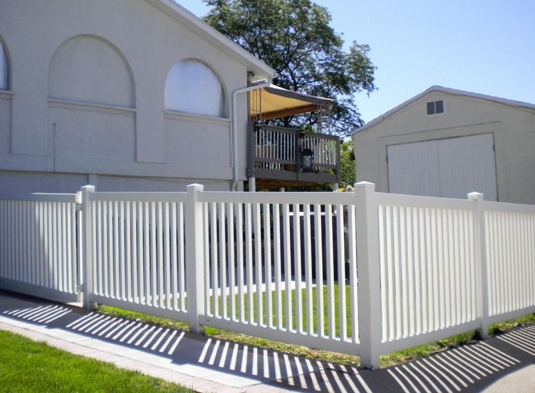 A white fence is in front of a house