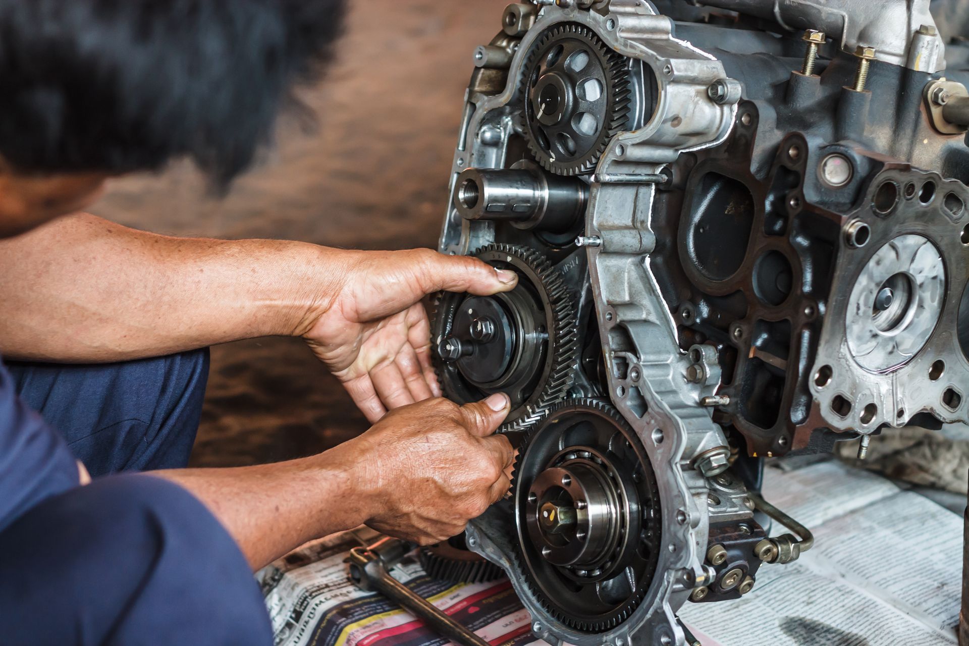 Hands Installing Gears on an Engine Block During Mechanical Repair — AA Automotive Repairs in Forster, NSW