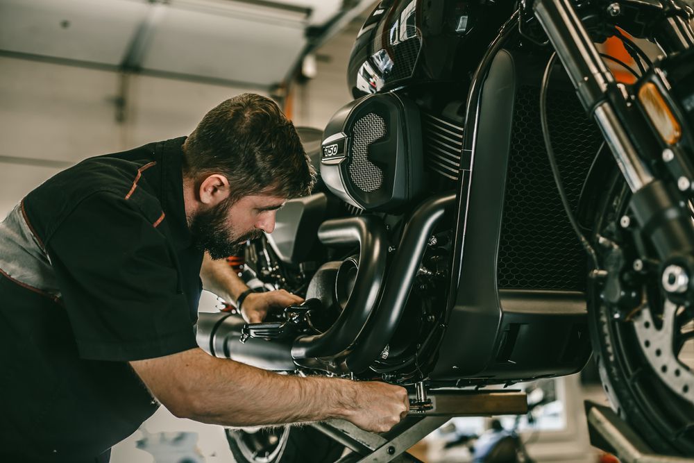 Mechanic Working on a Motorcycle in a Garage — AA Automotive Repairs in Forster, NSW