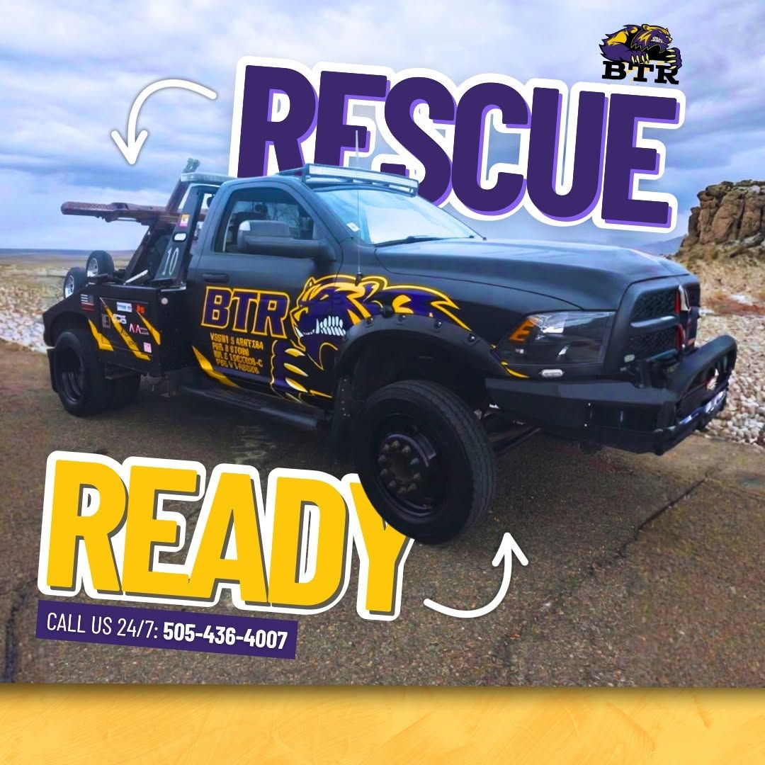 Black tow truck with bold “RESCUE READY” text and arrows on a roadside background.