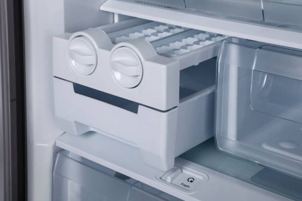 The inside of a refrigerator with a ice maker in it.