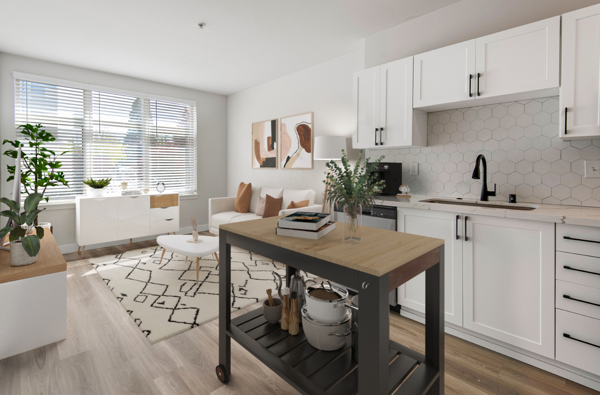 A kitchen with white cabinets and a small island in the middle
