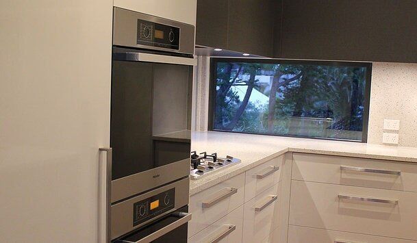 White Kitchen Cabinetry with Silver Accents — Craig Allman Construction Pty Ltd In Fernhill, NSW