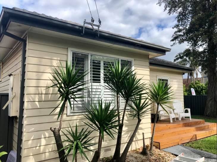 A White House With Palm Trees in Front of It — Craig Allman Construction Pty Ltd In Fernhill, NSW