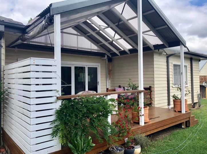 A Small House With a Porch and a White Fence Surrounding It — Craig Allman Construction Pty Ltd In Fernhill, NSW