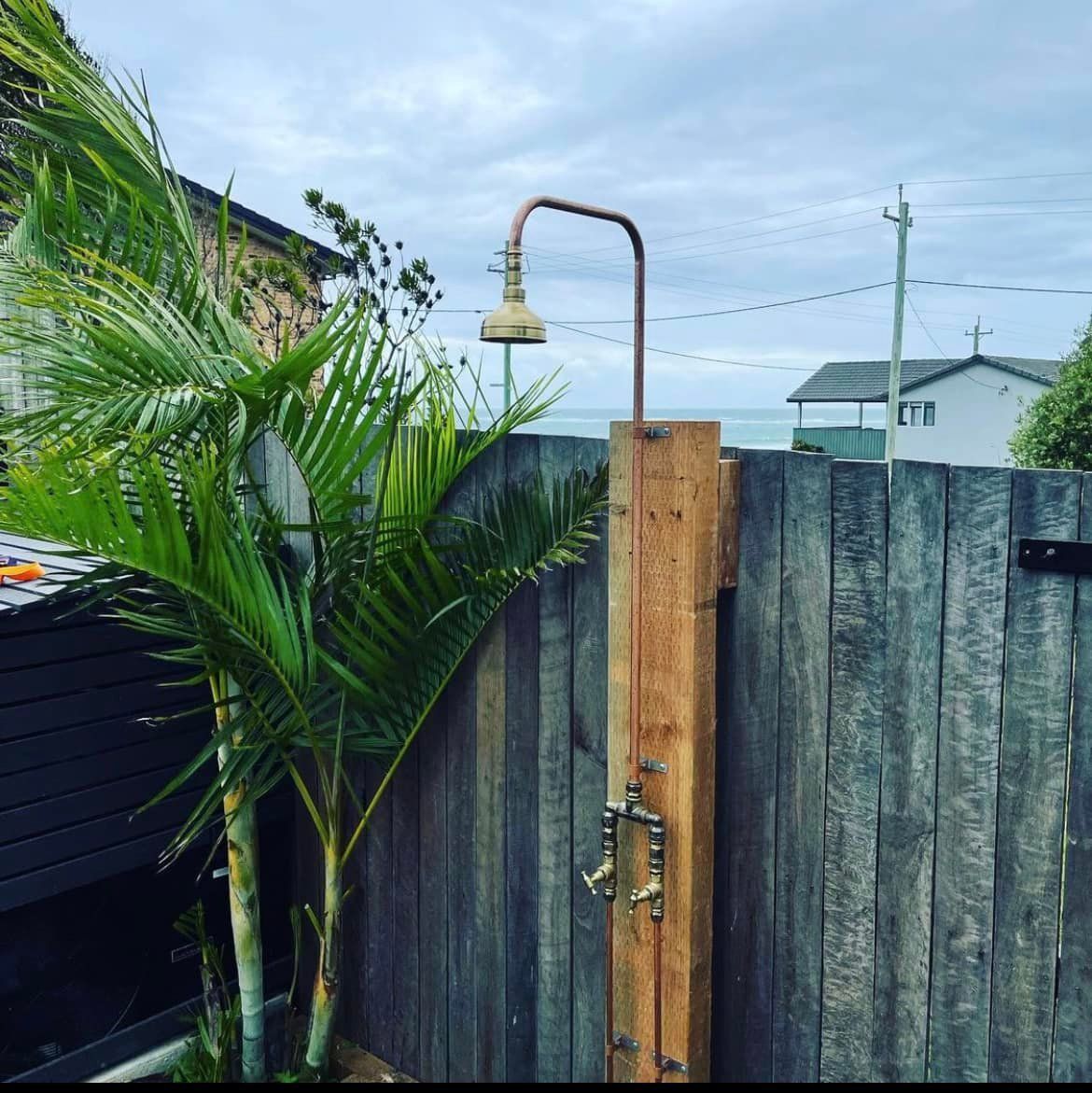 A Wooden Outdoor Shower is Attached to a Wooden Fence — Craig Allman Construction Pty Ltd In Fernhill, NSW