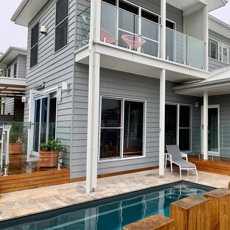 A Large House With a Swimming Pool in Front of It — Craig Allman Construction Pty Ltd In Fernhill, NSW