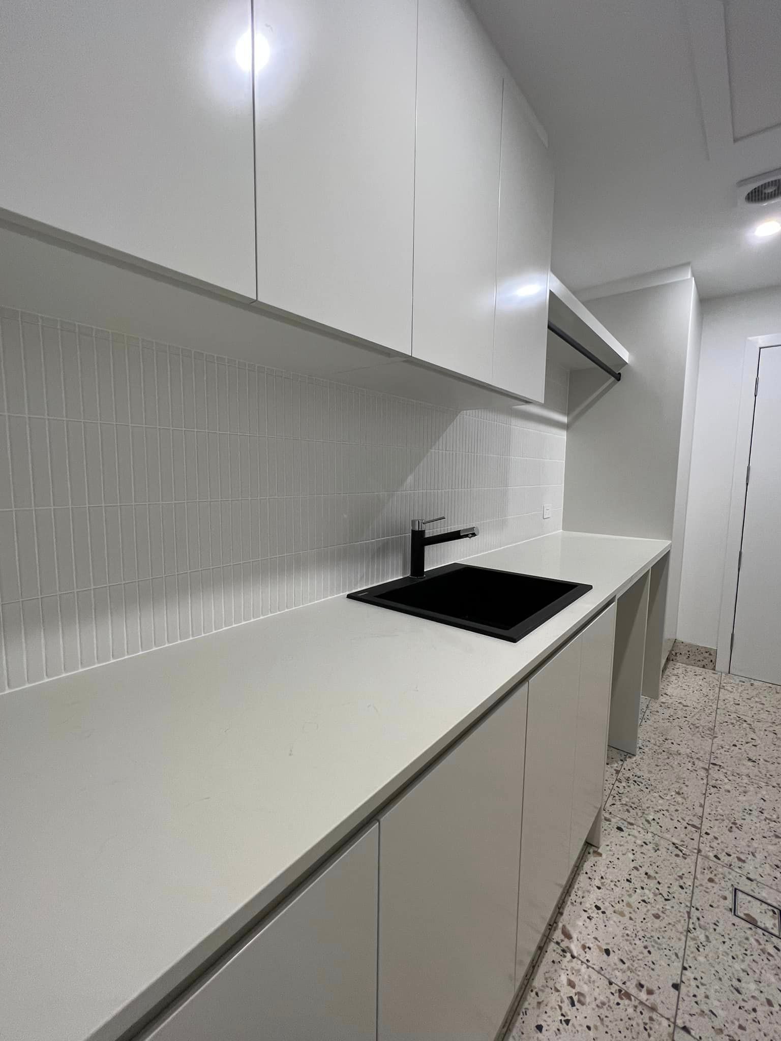 A Kitchen With White Cabinets and a Black Sink — Craig Allman Construction Pty Ltd In Fernhill, NSW