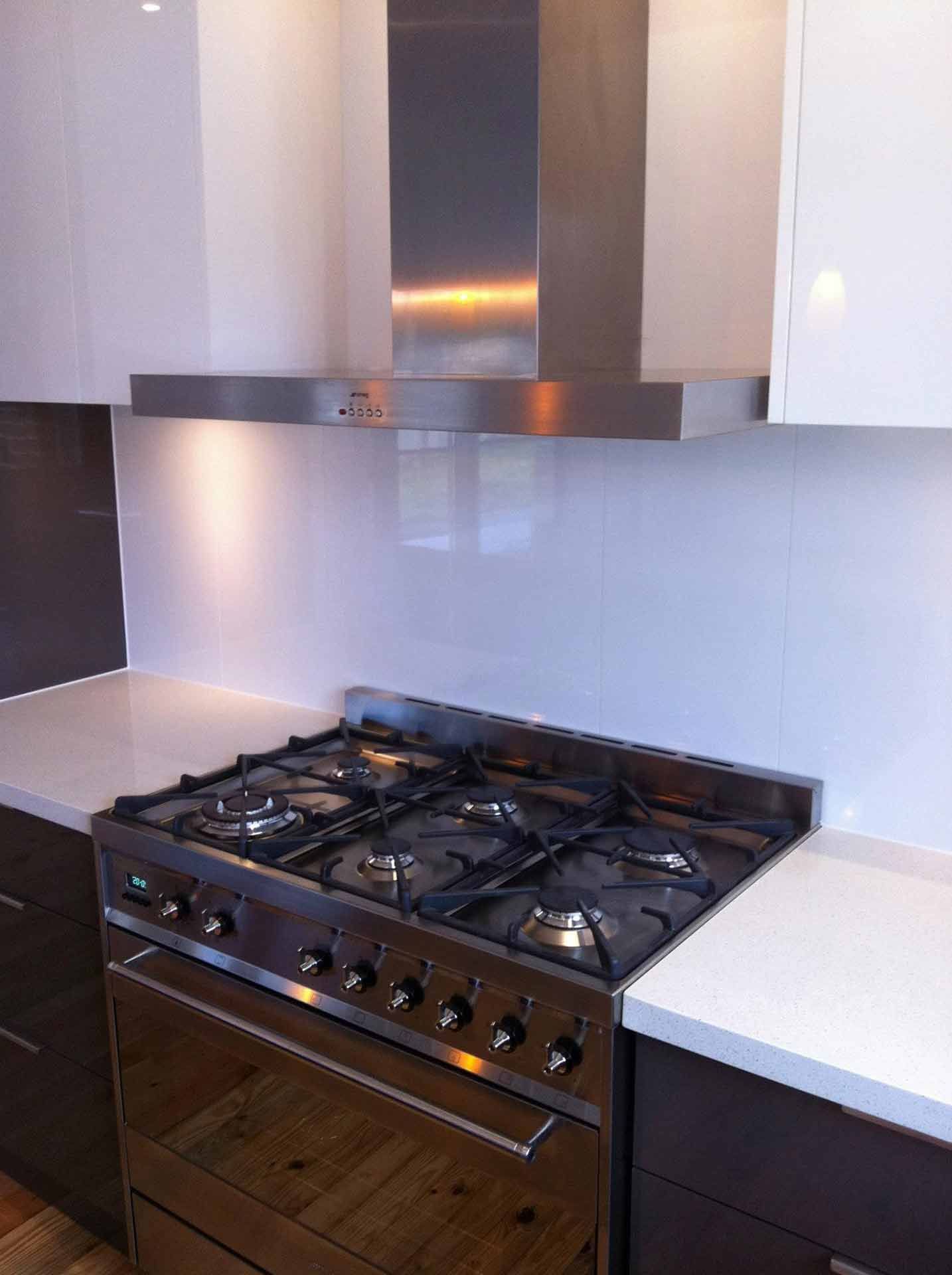 A Kitchen With a Stove Top Oven and a Hood Above It — Craig Allman Construction Pty Ltd In Fernhill, NSW