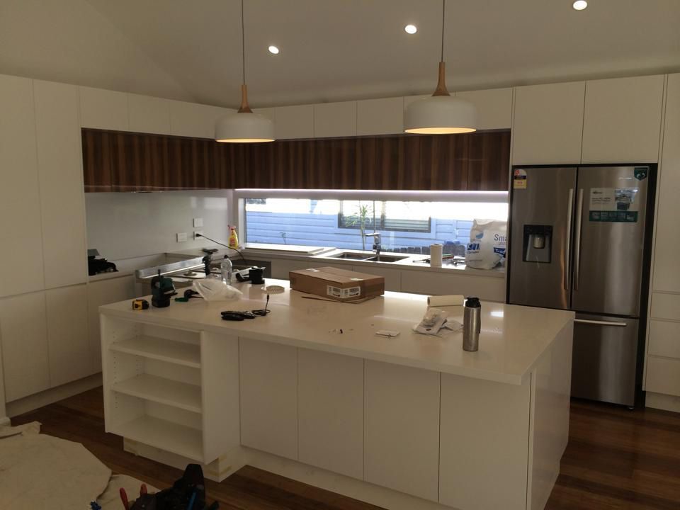 A Kitchen With White Cabinets and a Stainless Steel Refrigerator — Craig Allman Construction Pty Ltd In Shellharbour, NSW