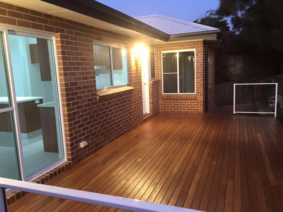A Brick House With a Wooden Deck in Front of It — Craig Allman Construction Pty Ltd In Fernhill, NSW