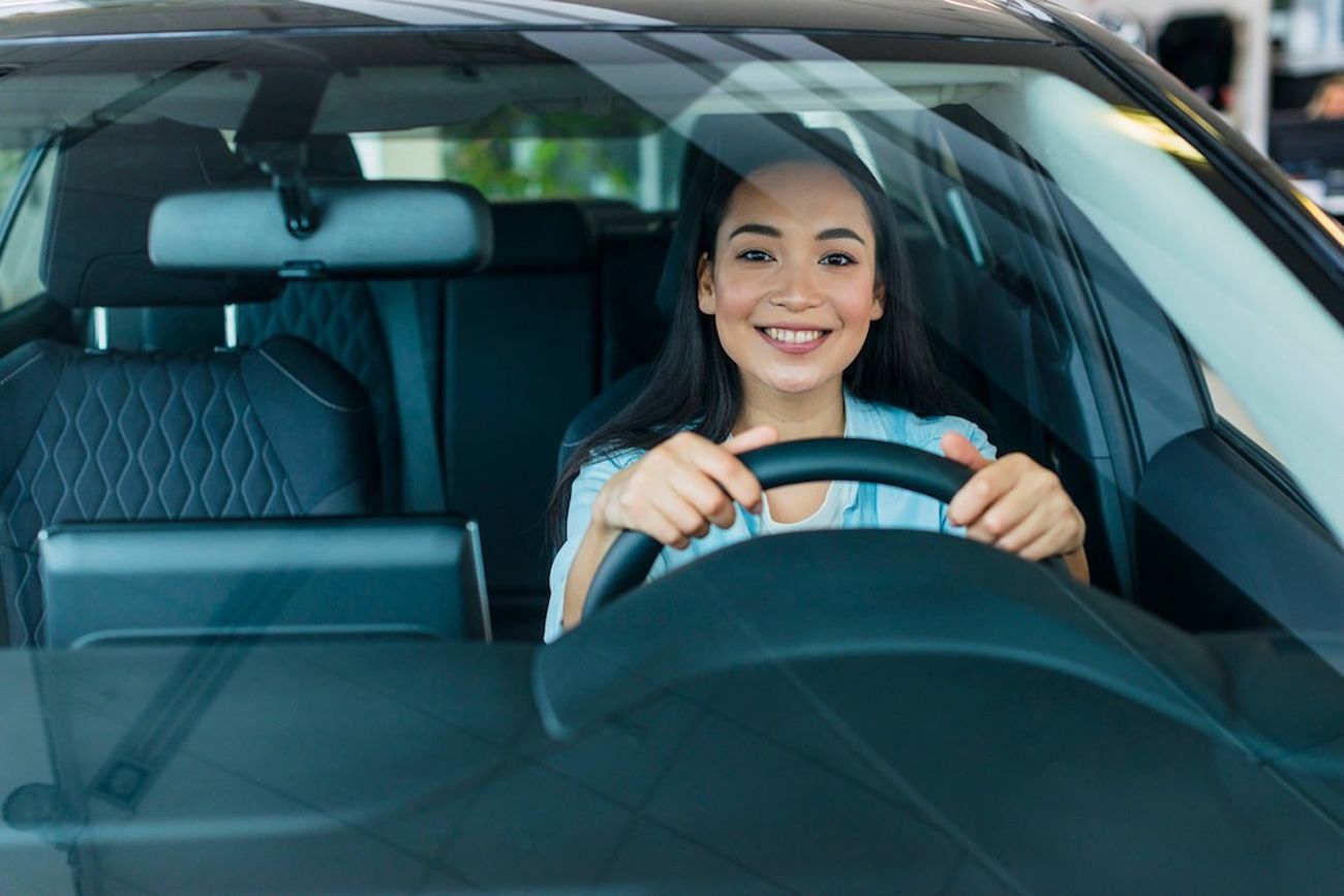 Smiling woman driving a car.
