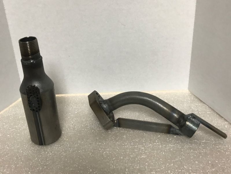 A bottle and a piece of metal are sitting on a table.