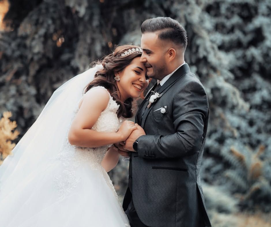 Bride and groom embracing outdoors, smiling in a romantic wedding portrait