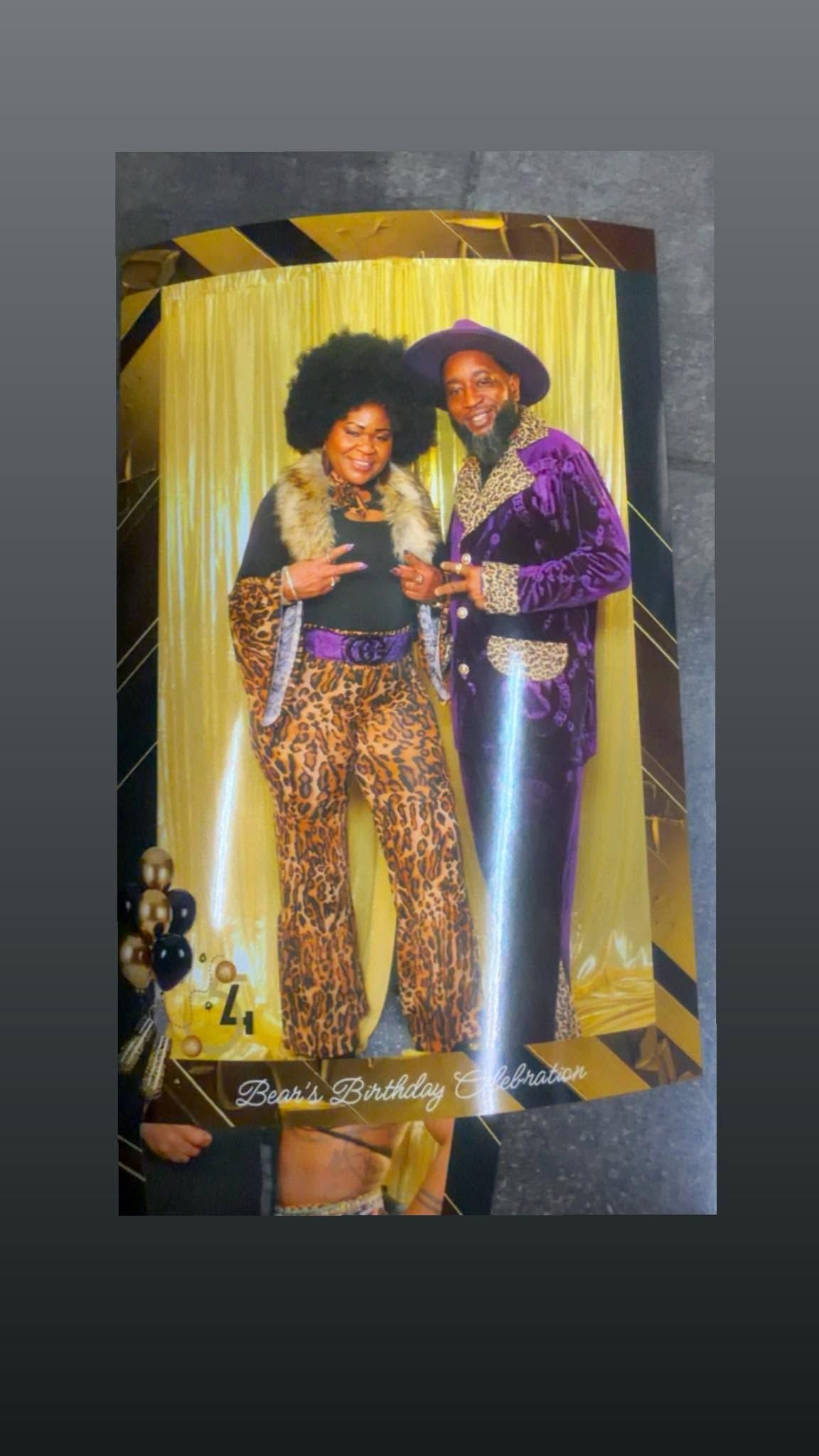 Two people in sparkly stage costumes pose together in front of gold curtains.