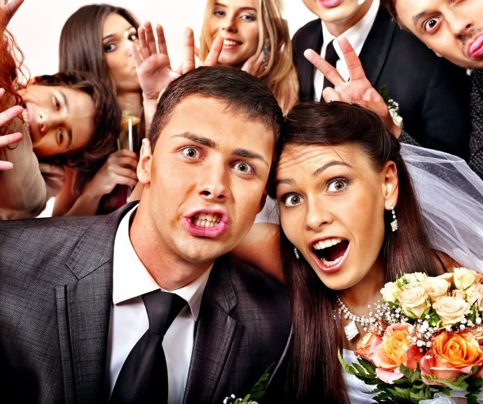 Crowded wedding selfie with smiling guests making playful faces and peace signs