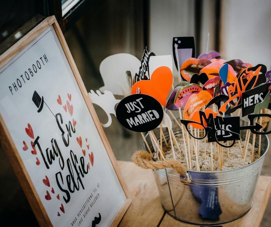 Photo booth props in a metal bucket beside a 