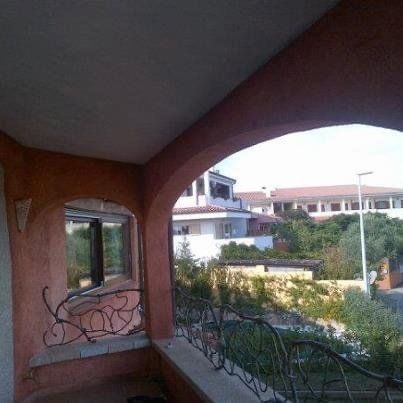 Vista dal balcone con ingresso ad arco, con vista sugli edifici e sul verde.