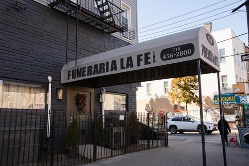 Funeraria La Fe storefront with black awning and gated entrance on a city street