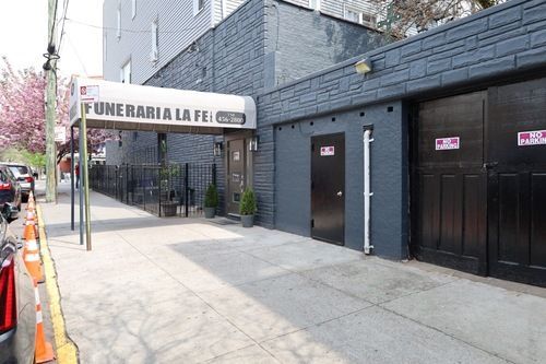 Funeraria La Fe storefront with dark doors along a city sidewalk