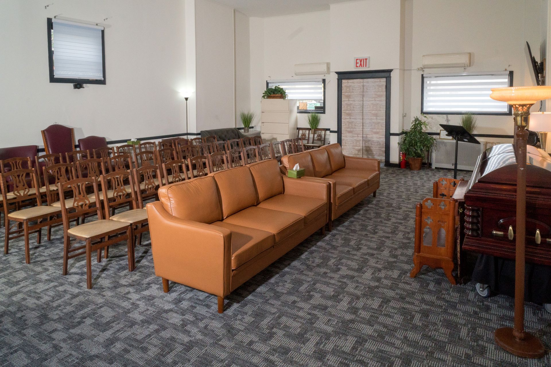 Empty waiting room with rows of chairs and benches in a softly lit interior