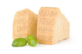 Due spicchi di parmigiano con foglie di basilico.