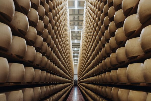 Assortimento di formaggi italiani, salumi, miele, vino e spumante rosé disposti su uno sfondo neutro.