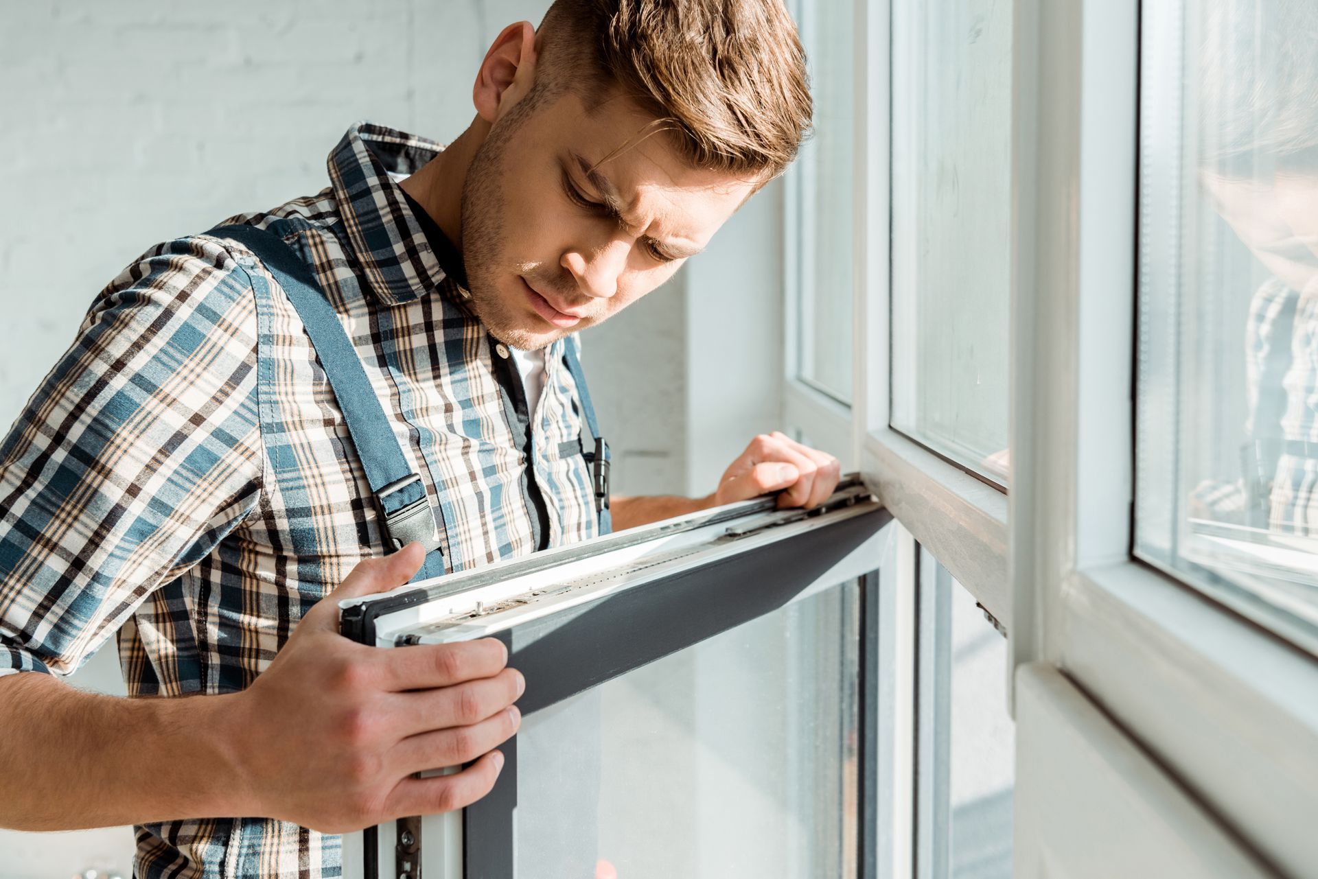 A man installing a window pane.