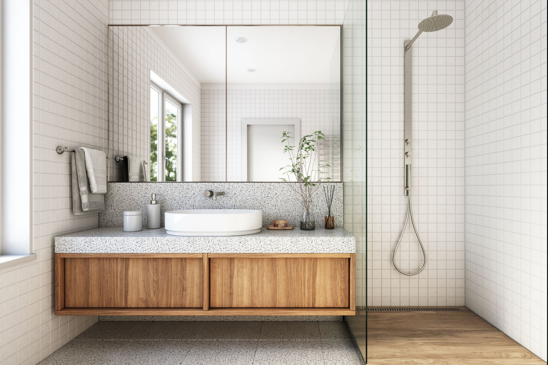 Modern bathroom with wood vanity, white sink, and shower with glass enclosure.