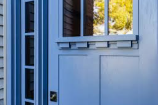 Blue door with window and decorative trim; light blue exterior.