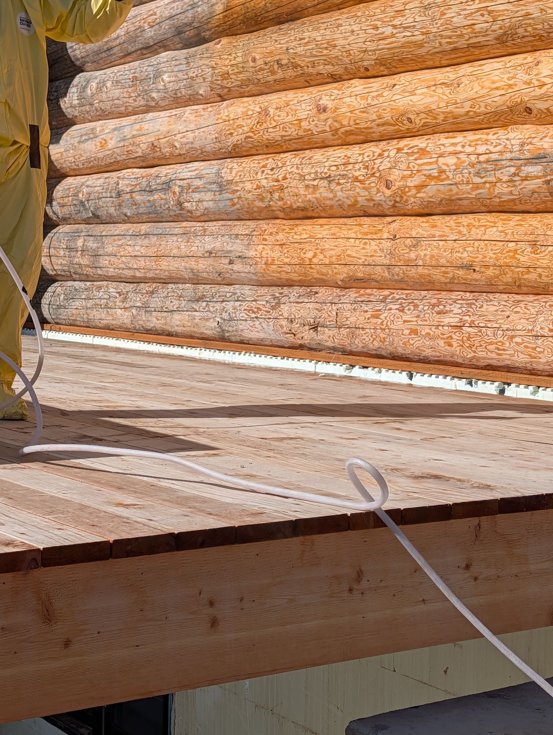 Stacked orange-brown wooden logs strapped with a white band, viewed from above.