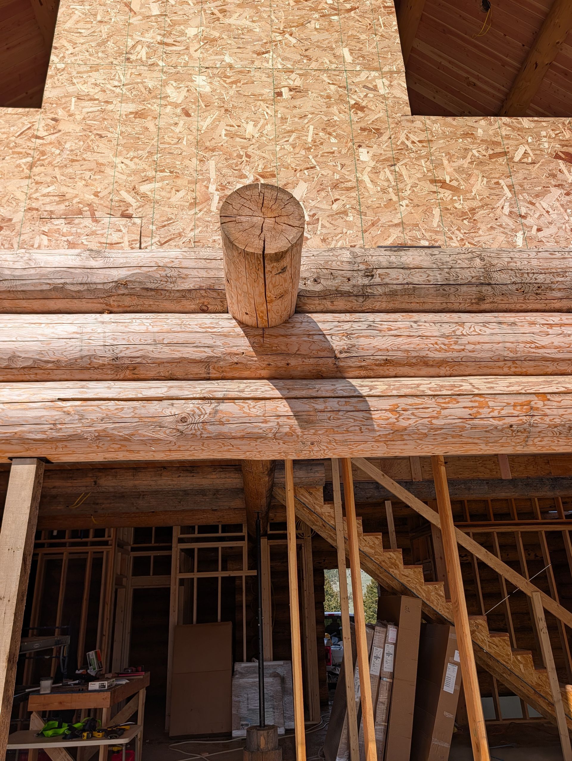 Wooden log beam and timber framing of an unfinished house under construction