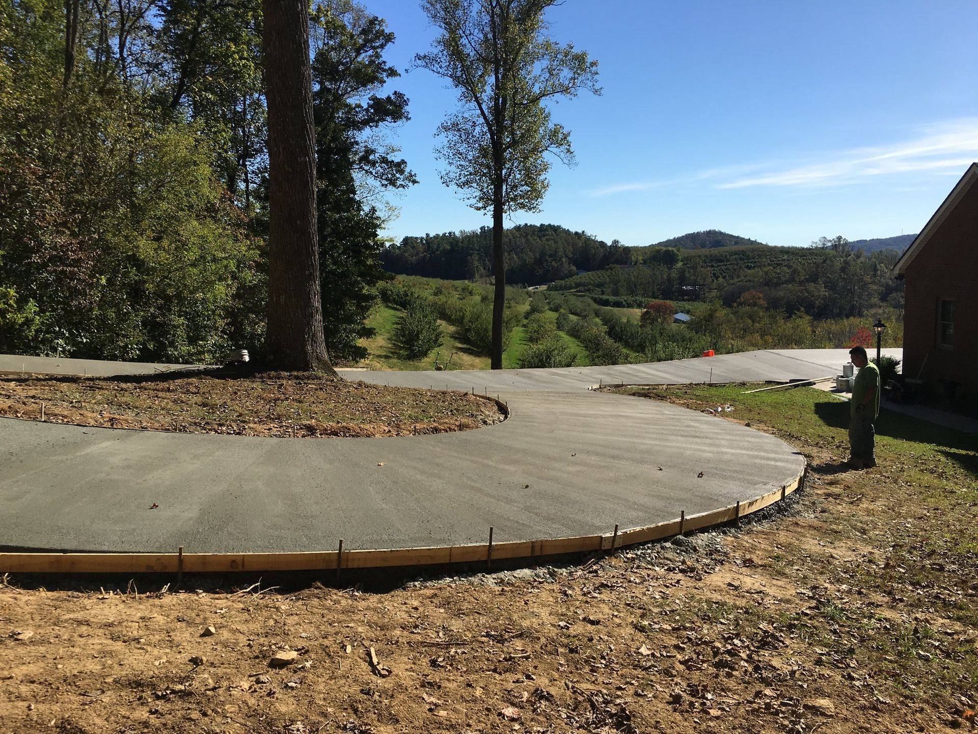 A concrete walkway is being built in front of a house