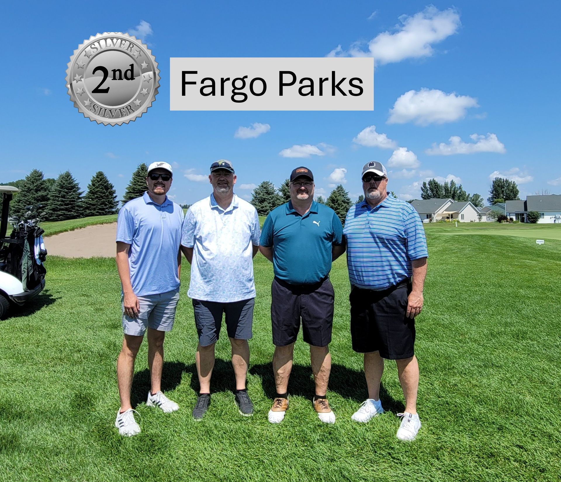 Four men standing on a golf course. Fargo Parks logo and 2nd place ribbon.