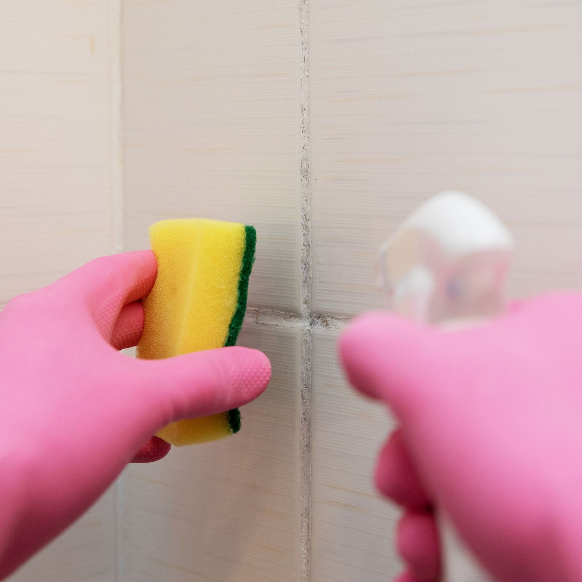 Arizona Carpet and Tile Steamers, Inc.- A person wearing orange gloves is cleaning a tile floor with a sponge.