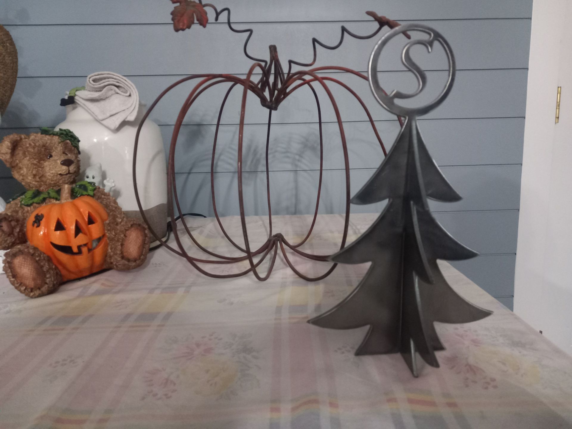 Fall decorations including a wire pumpkin, metal tree with