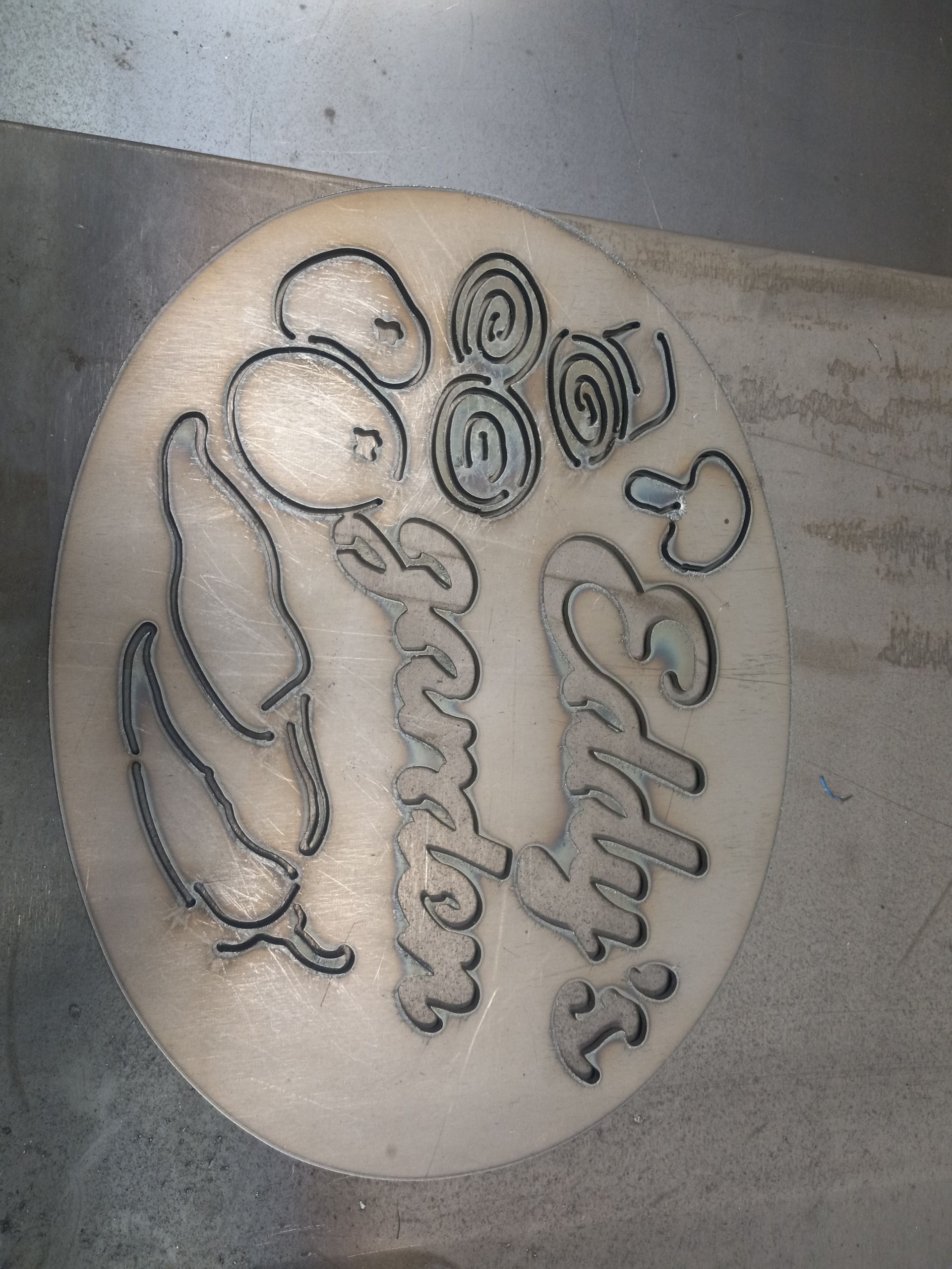Oval wooden plaque with etched illustrations of vegetables and the words