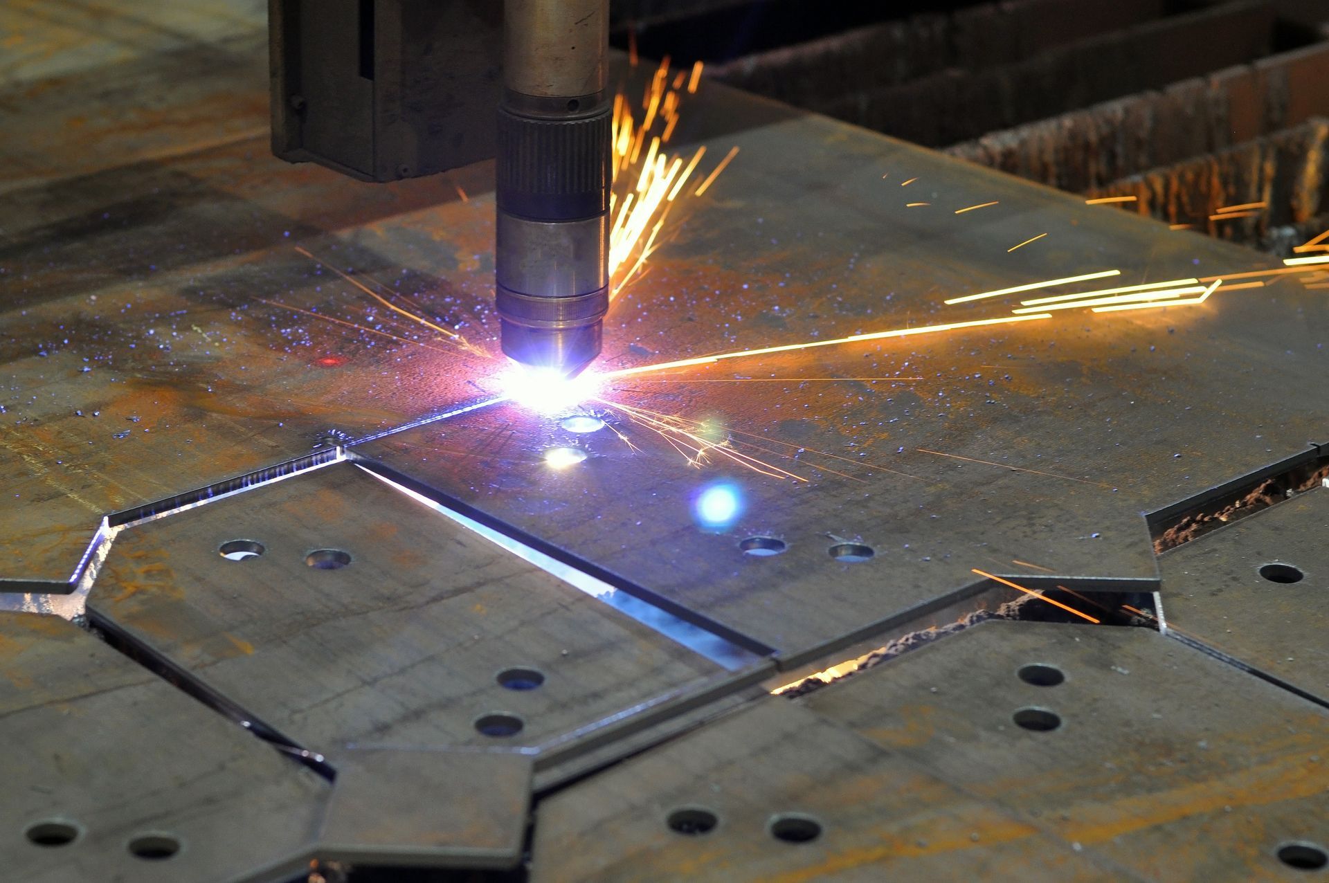 Metal sheet being bent by a hydraulic press, creating a sharp angle.