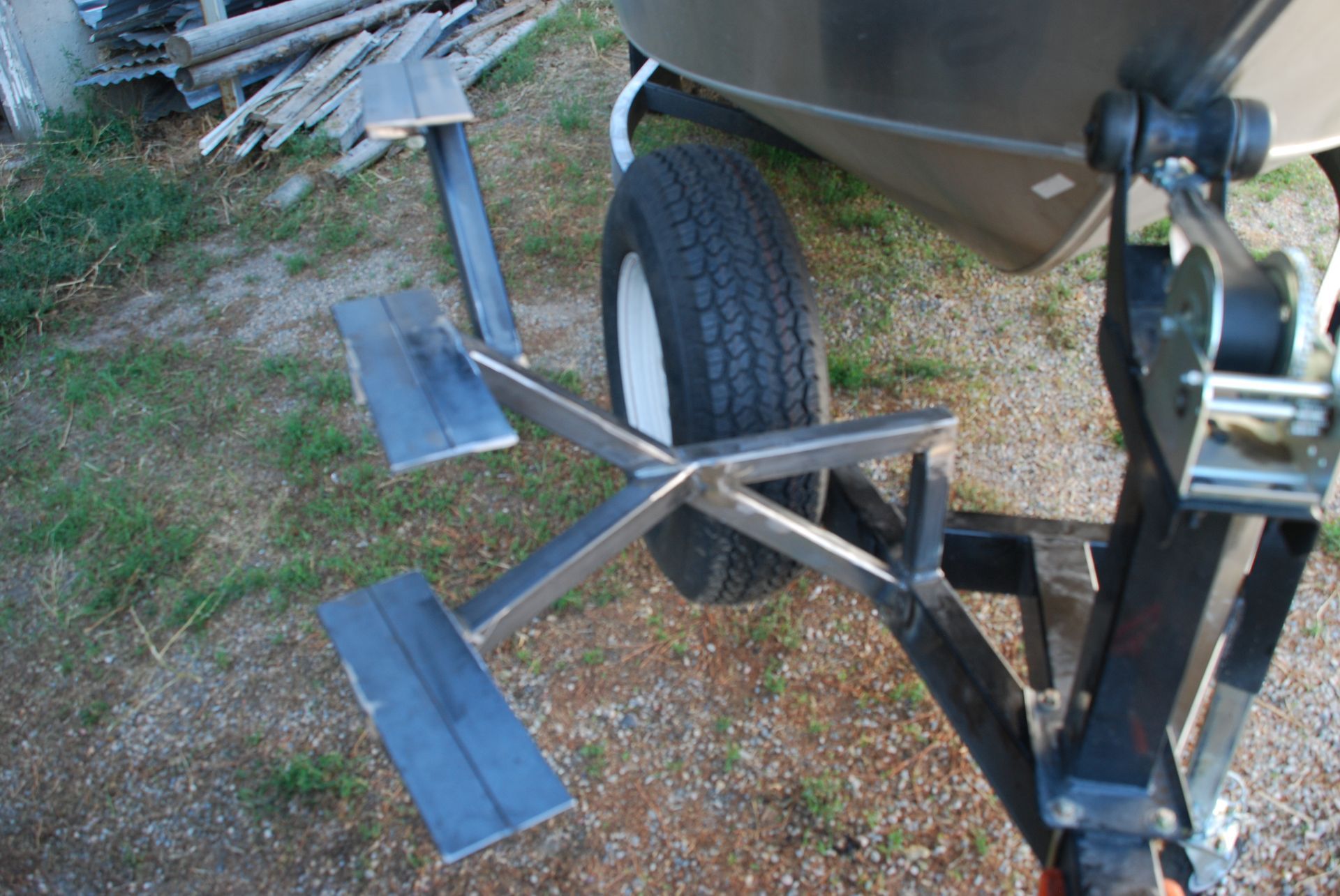Black tire on a car's suspension system, resting on a black curb.