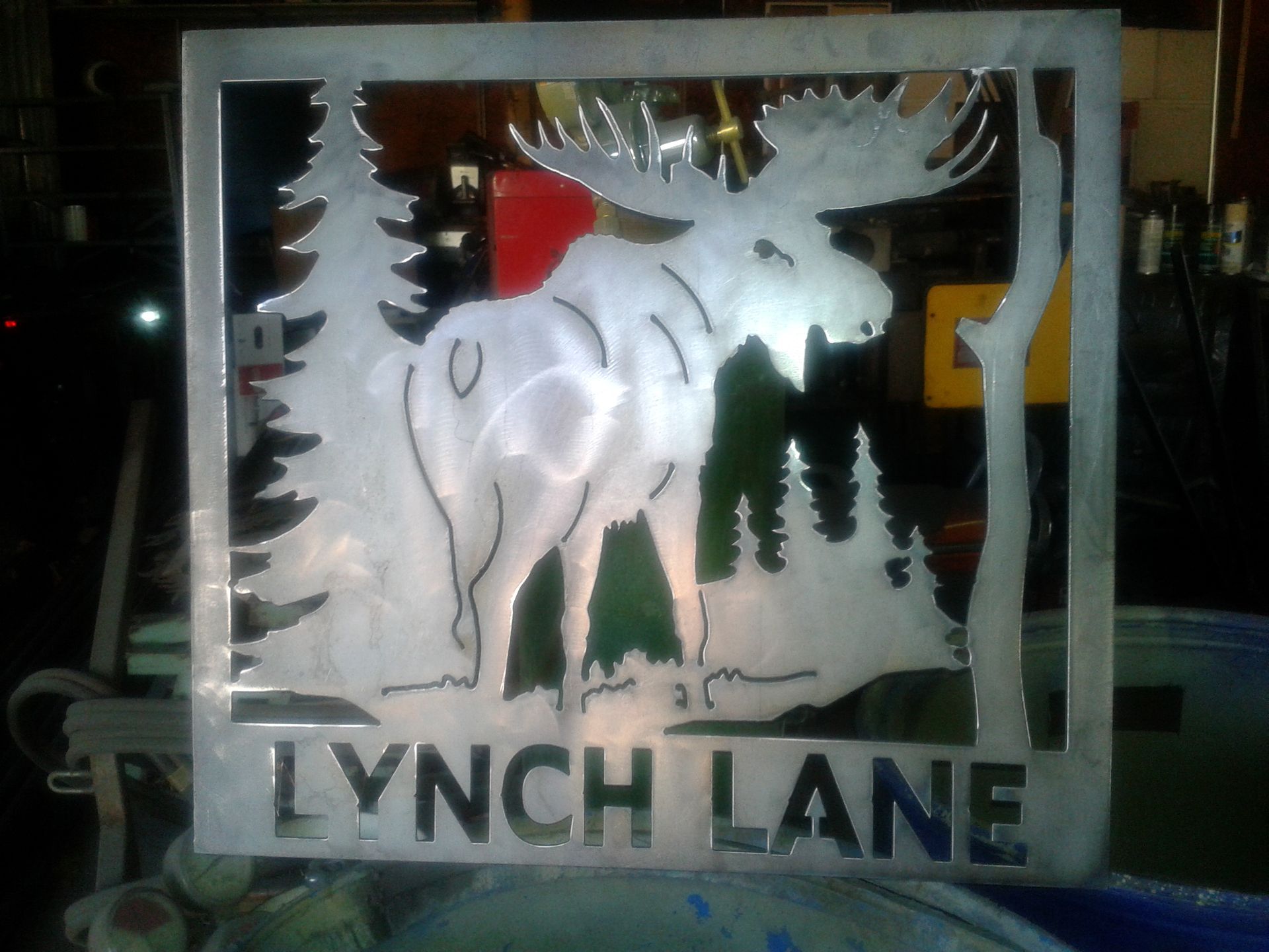 Metal sign: Moose with antlers in a forest scene,