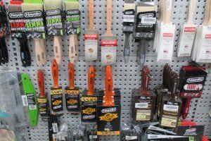 Paintbrushes of various sizes and styles displayed on a retail pegboard rack.