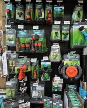 A retail store display of Gardena gardening supplies, including hose nozzles, connectors, and irrigation timers.