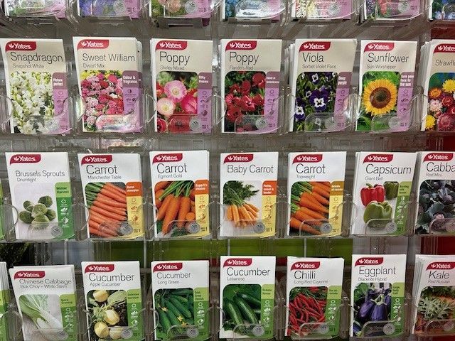 A display rack holding various Yates brand seed packets, including flowers and vegetables, arranged in rows.