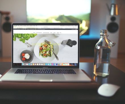 ein Computer auf einem tisch neben einer flasche wasser